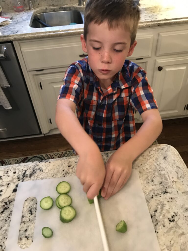 Jack diligently slicing cucumbers in the kitchen.