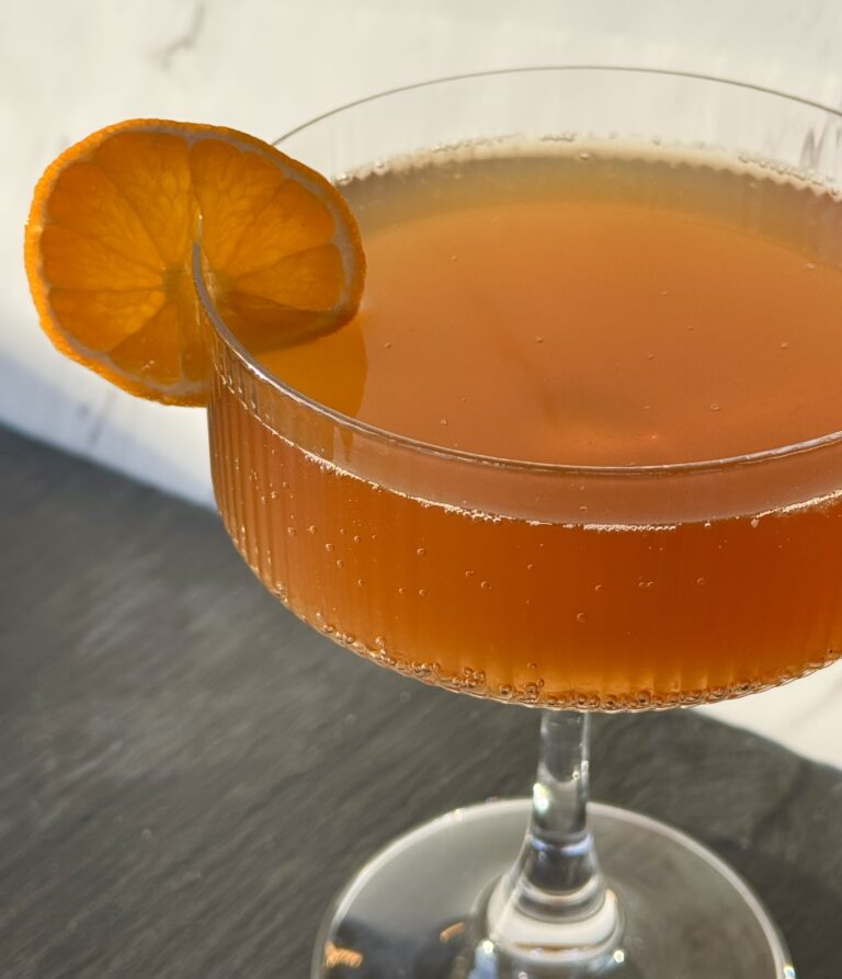 An orange slice on the side of a cocktail glass - but it's a mocktail