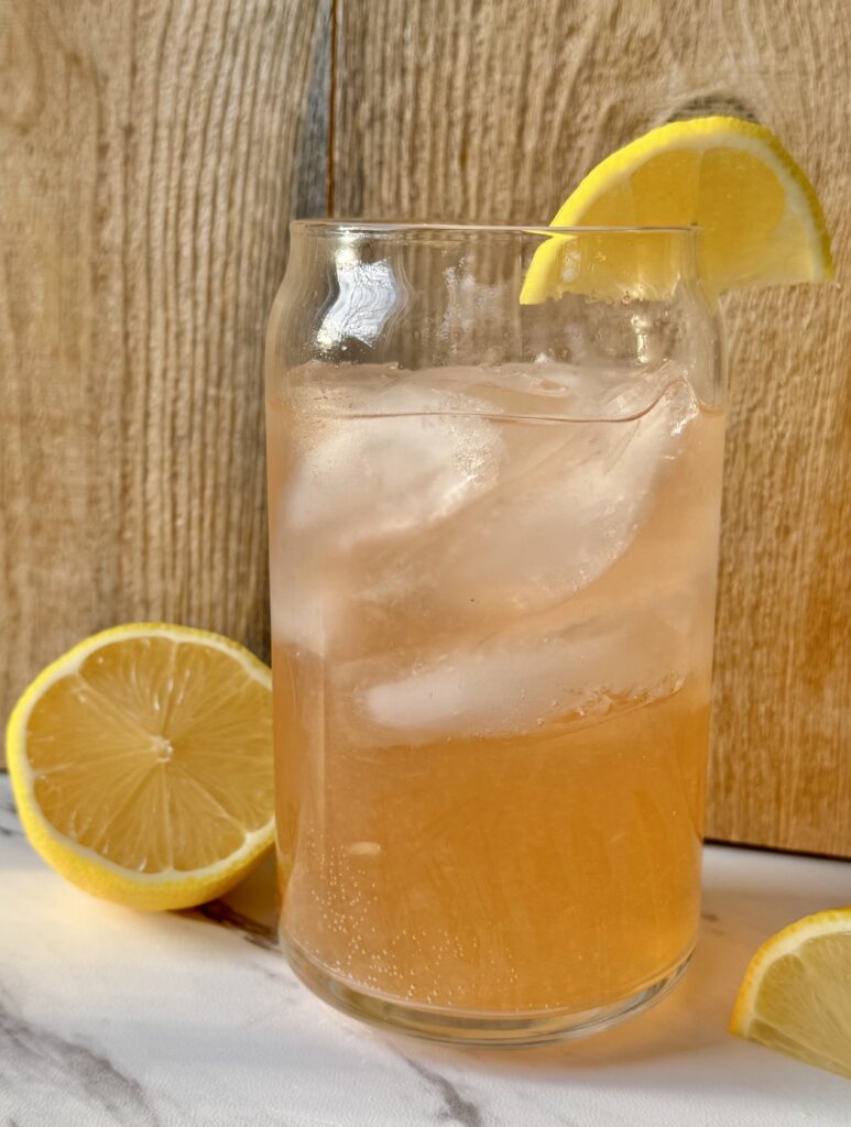 A glass filled with ice and sparkling water. Topped with a splash of bitters, fresh squeezed lemon and a lemon wedge.