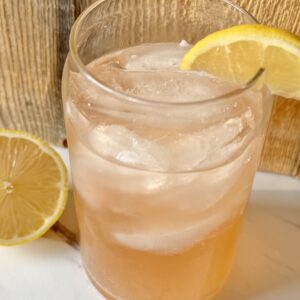 A glass filled with ice and sparkling water. Topped with a splash of bitters, fresh squeezed lemon and a lemon wedge.